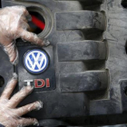 Un operario coloca la tapa de un motor diésel VW