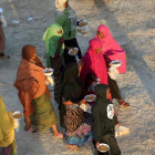 Unos inmigrantes caminan tras recibir comida en un centro de detención en Sabratha, el pasado 9 de octubre.