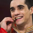 Javier Fernández muerde sonriente su medalla de oro.