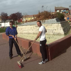 Dos operarios, durante la limpieza de la fuente que construyeron voluntarios de prisiones en Trobajo.