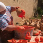 Mari Murciego aplica el baño de minio a las piezas que se cocerán en el horno árabe este fin de sema
