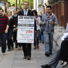 Un licenciado universitario en paro lleva una pancarta en la que pide trabajo, en Londres.