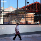 La vieja estación de RENFE se refleja en los ventanales de la moderna terminal de León