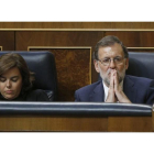 El presidente del Gobierno en funciones, Mariano Rajoy, y la vicepresidenta en funciones, Soraya Sáenz de Santamaría, esta tarde en su escaño durante la segunda sesión del debate de investidura.