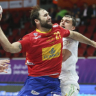 El jugador de la selección española de balonmano Joan Canellas encara con garra a un defensor bielorruso.