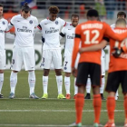 Los jugadores del PSG y del Lorient, durante el minuto de silencio previo al partido