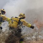 Dos brigadistas atacan un fuego en Benavides de Órbigo, a principios de este verano. JESÚS