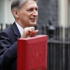 El ministro de Finanzas británico, Philip Hammond, posa con el tradicional maletín rojo del presupuesto.