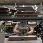 Un trabajador prepara un pedido en una caja de Amazon.