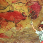 Un operario repara la reproducción de una de las pinturas que se encuentran en la cueva de Altamira.