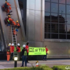 Activistas con la pancarta 'No al TTIP', justo al inicio de la escalada en una de las torres KIO.