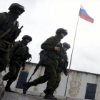 Un grupo de soldados armados camina cerca de un acceso a la base militar situada en la localidad de Perevalnoye, en los alrededores de Simferópol, en la península ucraniana de Crimea, el pasado día 7.