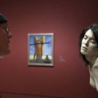 Un visitante observa una de las figuras expuestas.