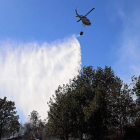 El helicóptero lanza agua sobre la zona afectada por las llamas. ICAL