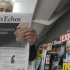 Un hombre lee el periódico «Les Echos», en Burdeos, tras la detención de Strauss-Khan.