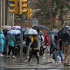 Viandantes se protegen de la lluvia en Barcelona, en una imagen de archivo.