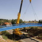 Una grúa sitúa el puente sobre las zapatas de apoyo. MARCIANO PÉREZ