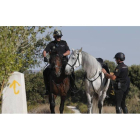 Dos agentes de la unidad de Caballería, junto a uno de los hitos de la ruta