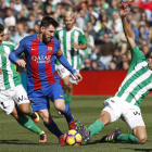 El argentino Leo Messi intenta zafarse del férreo marcaje de dos jugadores del Betis. JULIO MUÑOZ