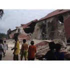 Varios filipinos observan la destrucción causada en la catedral de San Pedro, en Loboc (provincia de Mohol), este martes.