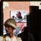 Un soldado custodia un centro de voto con un cartel electoral de Al Sisi.