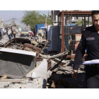 Un policía inspecciona la escena de un coche bomba en Sadr City.