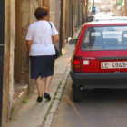 Una mujer camina por la estrecha acera de Fernández Cadórniga