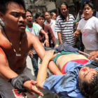 Manifestantes cargan con uno de los muertos durante los enfrentamientos.