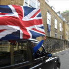 Un motorista con una bandera británica en el centro de Londres.
