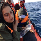 Una madre llora rodeada de sus hijos en una barca de rescate de Open Arms.