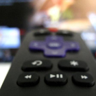 Mando a distancia ante un televisor inteligente con conexión a plataformas de TV por internet.
