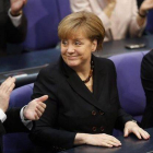 Merkel (en el centro) sonríe al recibir los aplausos de los diputados del Bundestag tras la reelección, este martes en Berlín.