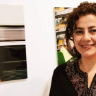 La artista Alicia Juan Lobato posa junto a una de las fotografías que expone en León.