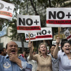 Manifestantes contrarios a Maduro sostienen pancartas en las que reclaman que se acabe la dictadura en Venezuela.