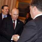Putin estrecha la mano de Poroshenko.
