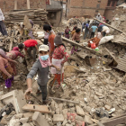 Varias personas buscan sus pertenencias en las ruinas de un edificio en Bhaktapur.
