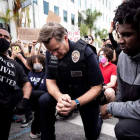 Imagen de un policía arrodillado como muestra de respeto ante las protestas en Los Angeles. ETIENNE LAURENT