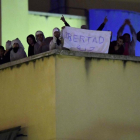 Algunos de los amotinados muestran un cartel que pide Libertad, en la azotea del CIE de Aluche