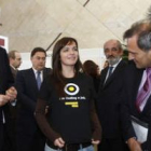 Una joven muestra la camiseta con la que busca empleo a Hermida, Martínez y Fernández; detrás Marcos