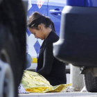 Una mujer permanece junto al cadáver del hombre tiroteado.