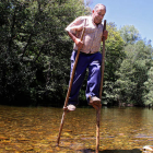 Pepín utiliza unas zancas para atravesar el río Omaña. PEIO GARCÍA/ICAL