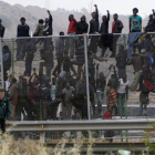 Inmigrantes encaramados a la valla de Melilla el jueves 1 de mayo.