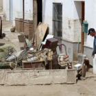 Un vecino de Cañete de las Torres saca enseres deteriorados.