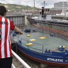 Dos jóvenes observan la gabarra con la que el Athletic Club celebró sus títulos en 1983 y 1984, que no saldrá del Museo Marítimo de Bilbao para festejar la Supercopa de España.