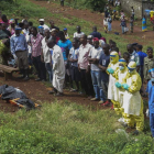 Unas personas rezan frente al cadáver de una víctima del ébola en Freetown, Sierra Leona.