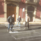 Un grupo de vecinos de Cistierna pintando con tizas los pasos de peatones. CAMPOS