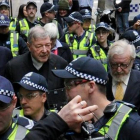 El cardenal George Pell (en el centro) sale de la Audiencia, en Melbourne.