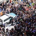 Decenas de personas intentan impedir que salga el coche de la Guardia Civil tras el registro al Departament dAfers Exteriors de la Generalitat.