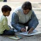 Una abuela enseña a su nieto a pintar durante un certamen de pintura