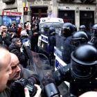 Manifestantes forcejean con mossos ante la Delegación del Gobierno en Cataluña.